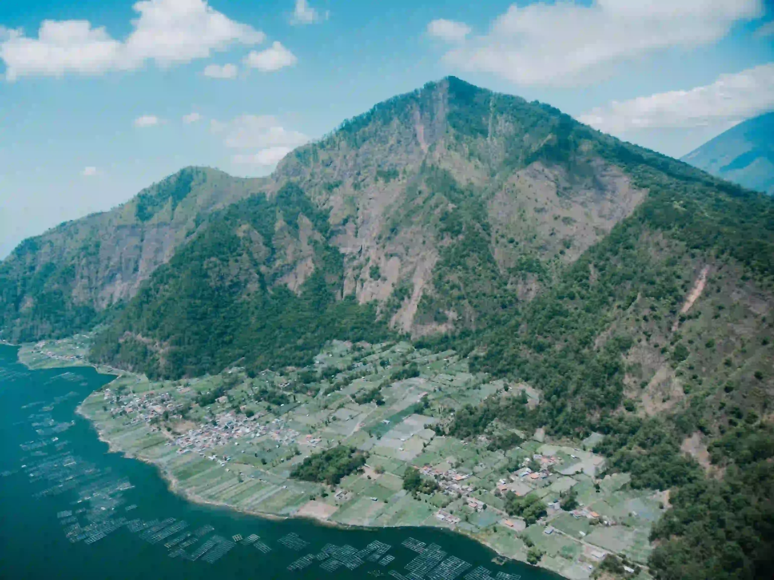 Mount Batur volcano crater lake aerial view from helicopter